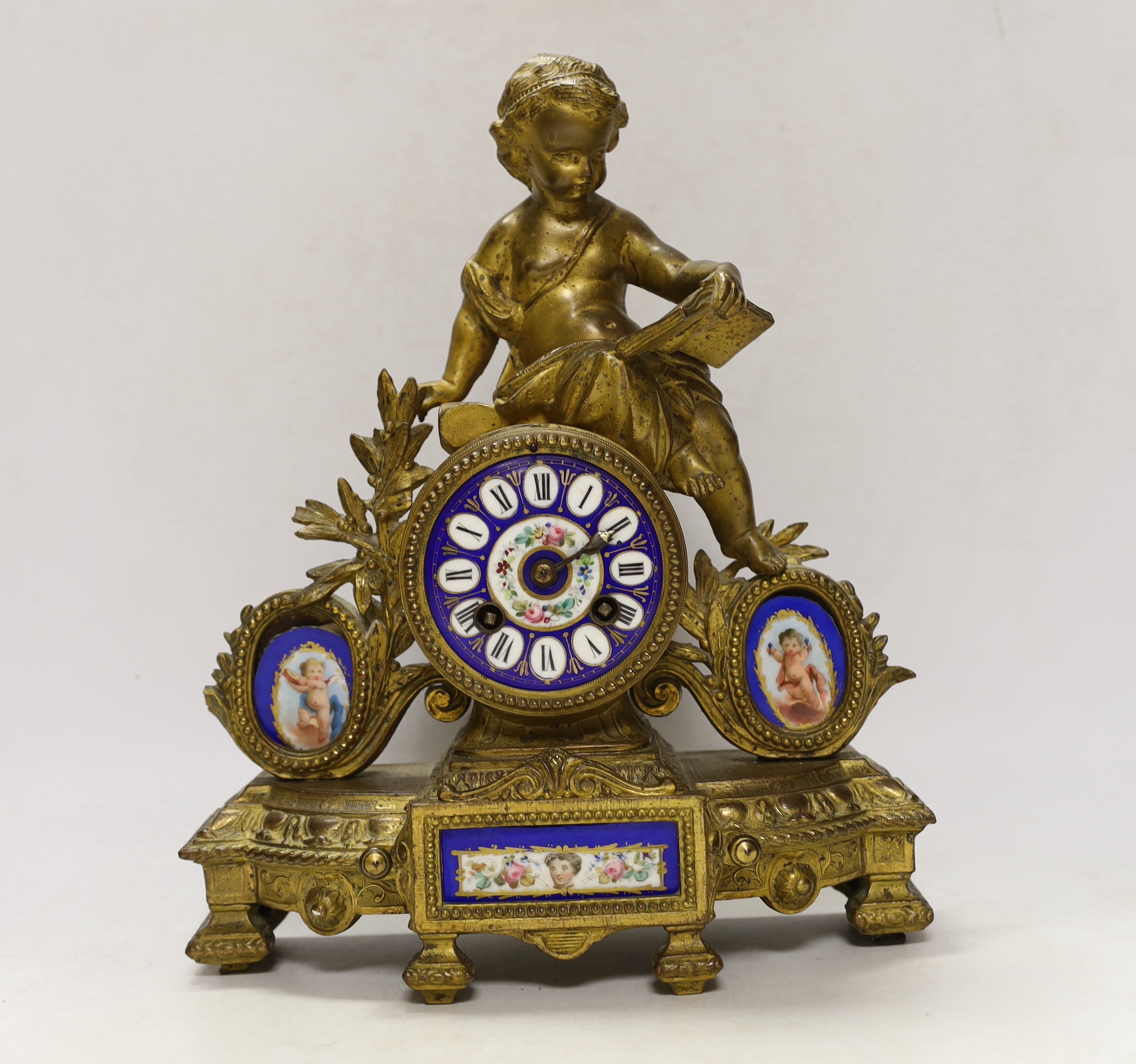 A 19th century ornate French gilt brass and porcelain clock, with two matching two branch candelabra garnitures, clock 31cm high